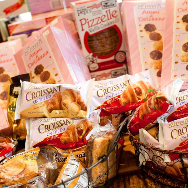 Baskets filled with packaged croissants, cookies, and waffle cookies, including Bauli and Pepi's brands.